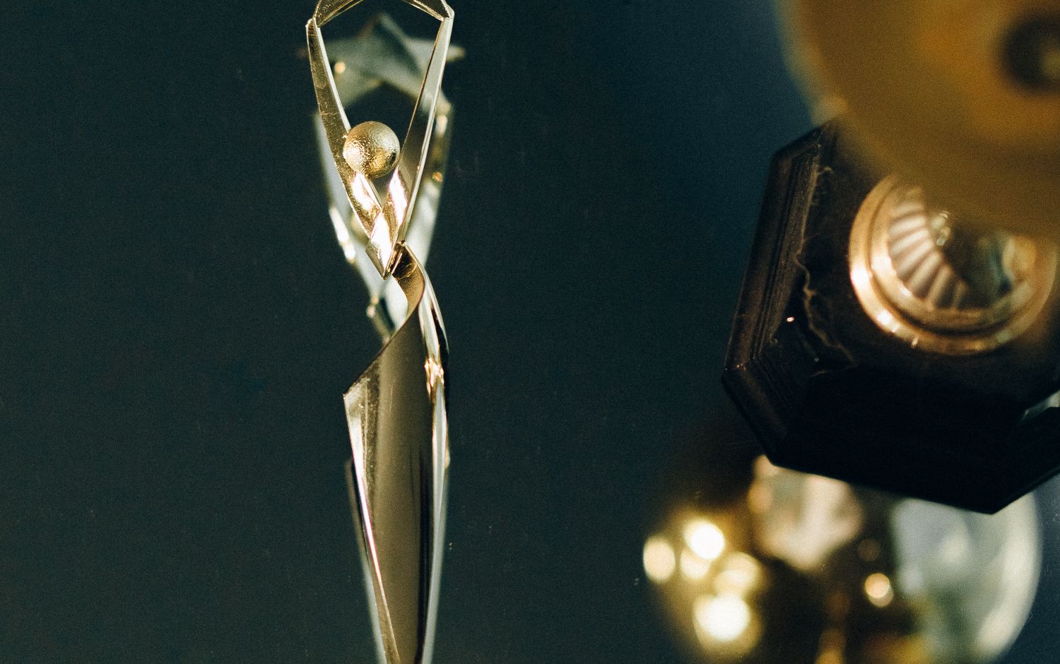 A gold star award catching the light at an evening ceremony