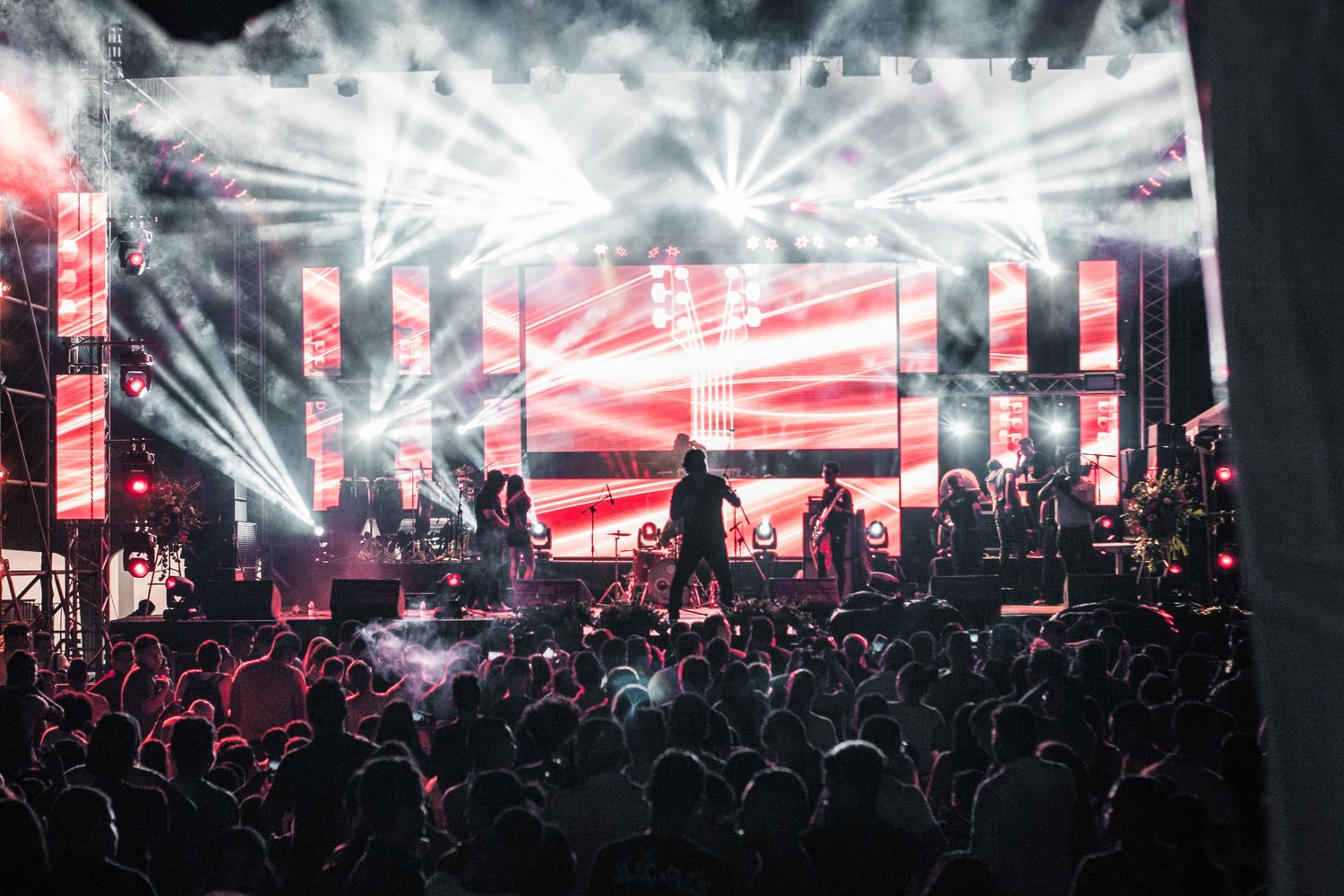 Performers on a lit stage in front of a large crowd