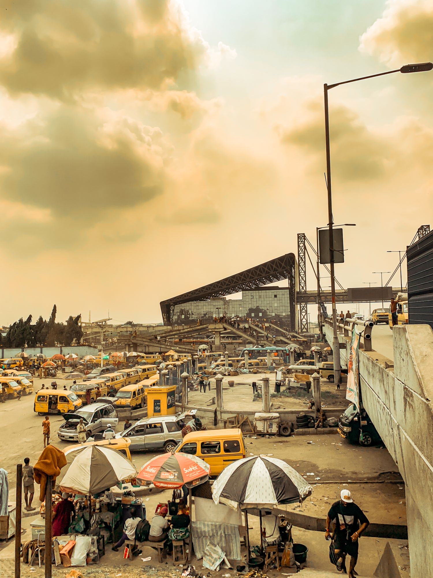A Lagos street market at sunset, traders and buyers under low light