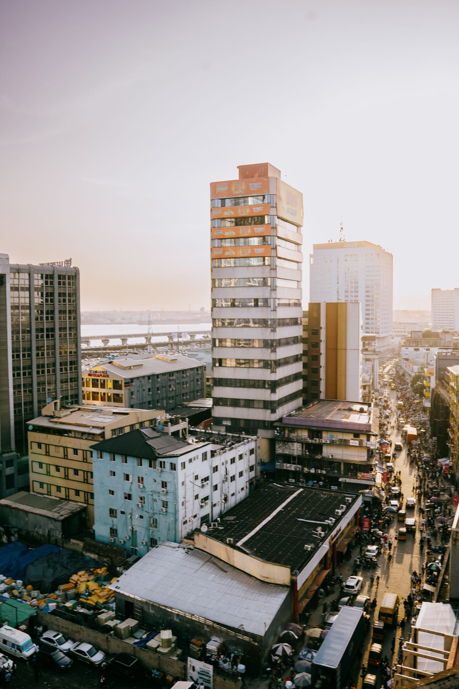 Lagos Island at sunset, high rise towers above a busy market street